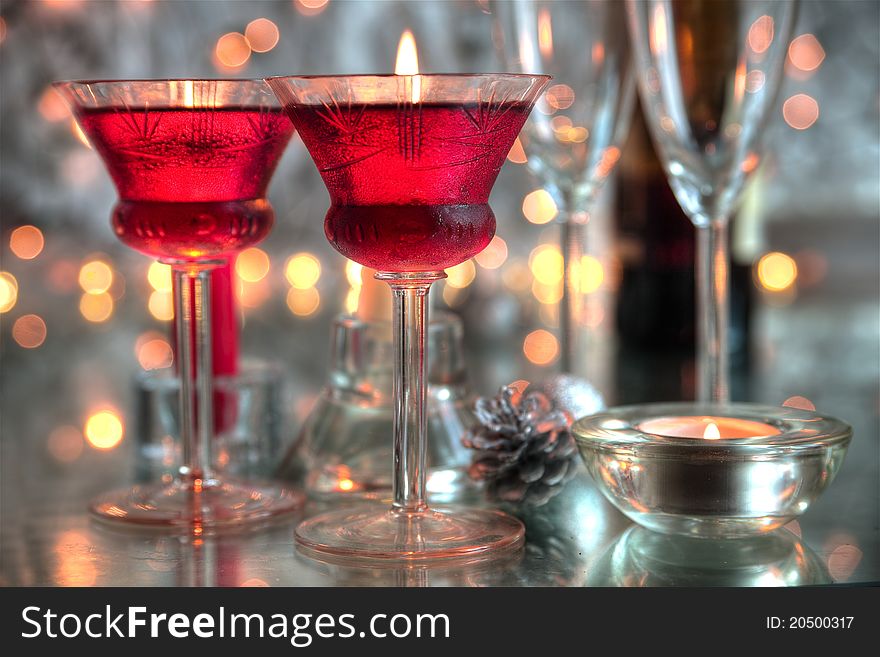 Close-up of glasses with red wine,candle light and twinkle lights on background. Close-up of glasses with red wine,candle light and twinkle lights on background.