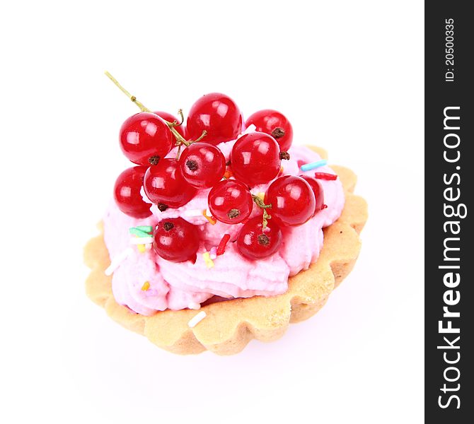 Tartlet with whipped cream, red currants and sprinkles on a white background