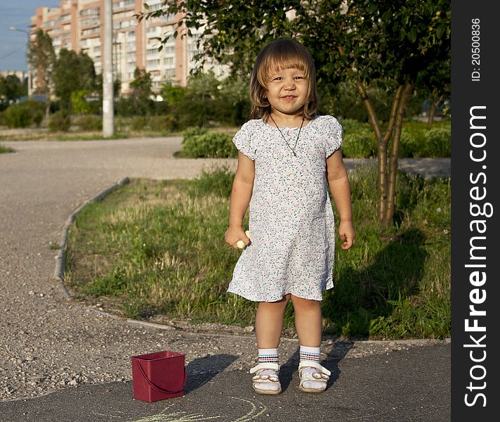 Portrait of blonde little girl outdoors in summer