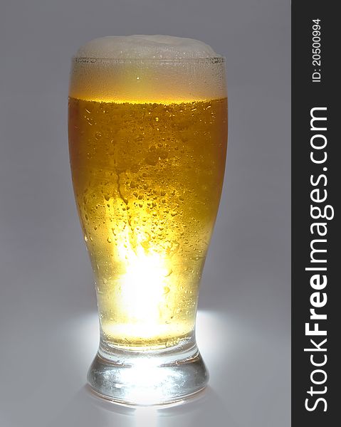 Beer is in glass on grey background