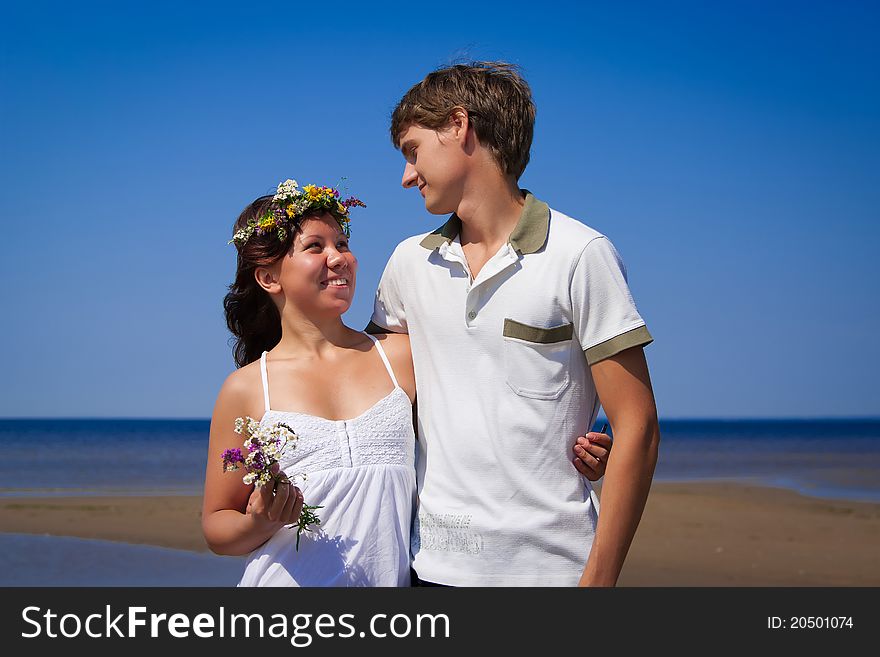 Beautiful young couple on the sandy sea coast. Beautiful young couple on the sandy sea coast