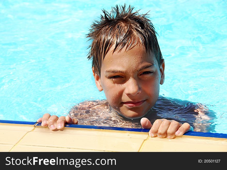 Wet young smiling boy portrait in blue resort swimming pool. Wet young smiling boy portrait in blue resort swimming pool
