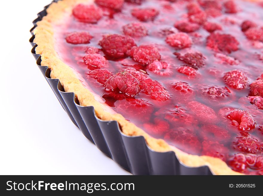 Raspberry Tart in a tart pan on a white background