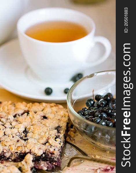 Breakfast with homemade blueberry pie, bowl of fresh blueberries and white cup of tea. Breakfast with homemade blueberry pie, bowl of fresh blueberries and white cup of tea