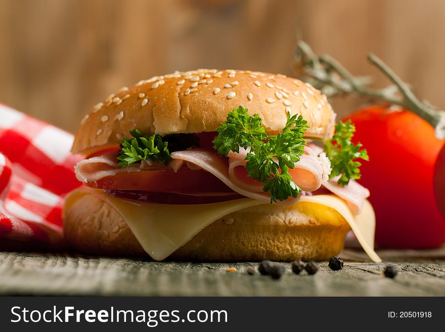 Fresh sandwich with cheese, ham and tomato on wooden table. Fresh sandwich with cheese, ham and tomato on wooden table