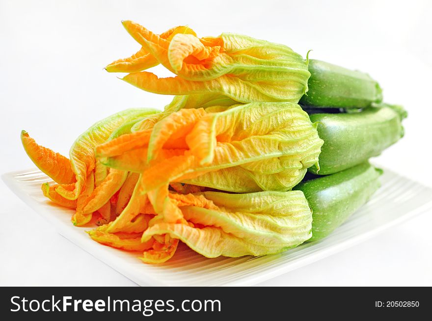 Zucchini with flowers on a white background