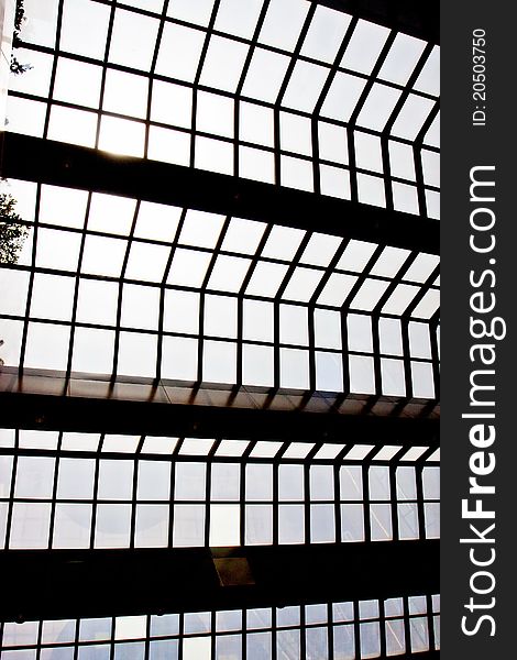 Modern glass ceiling with blue sky and sun