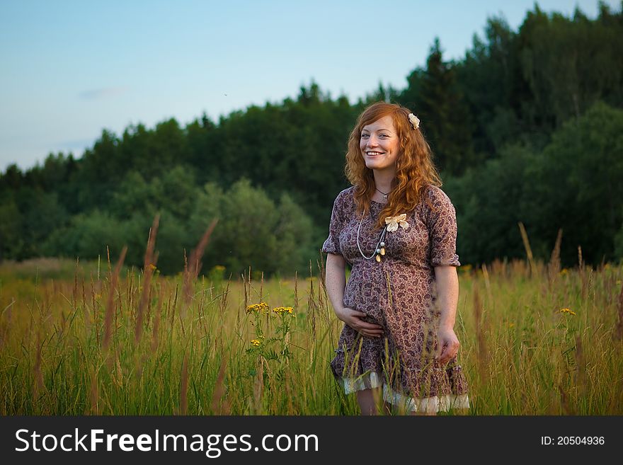 Beautiful pregnant girl on the field