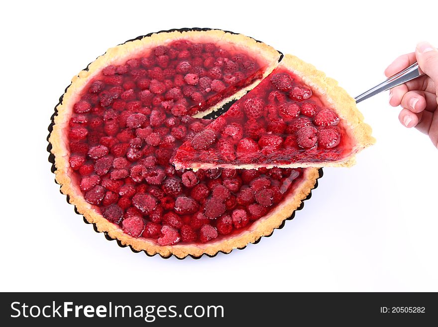 Raspberry Tart - a portion on a cake server being held by a woman's hand