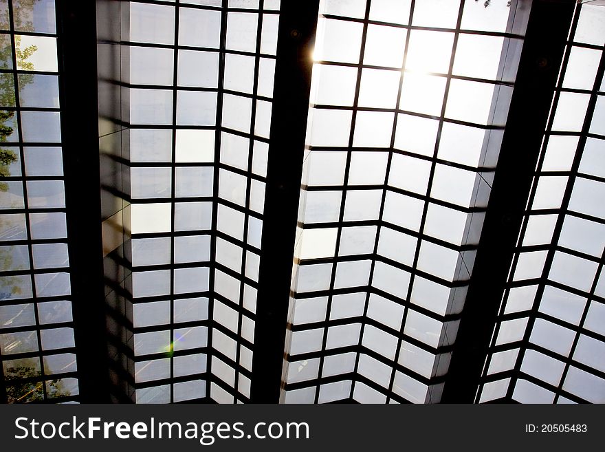 Modern glass ceiling with blue sky and sun