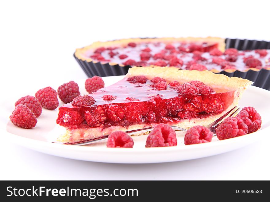 Raspberry Tart in a tart pan and a portion on a plate