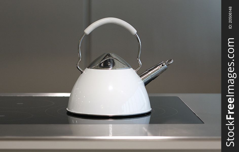 White kettle on the stove in modern kitchen. White kettle on the stove in modern kitchen.