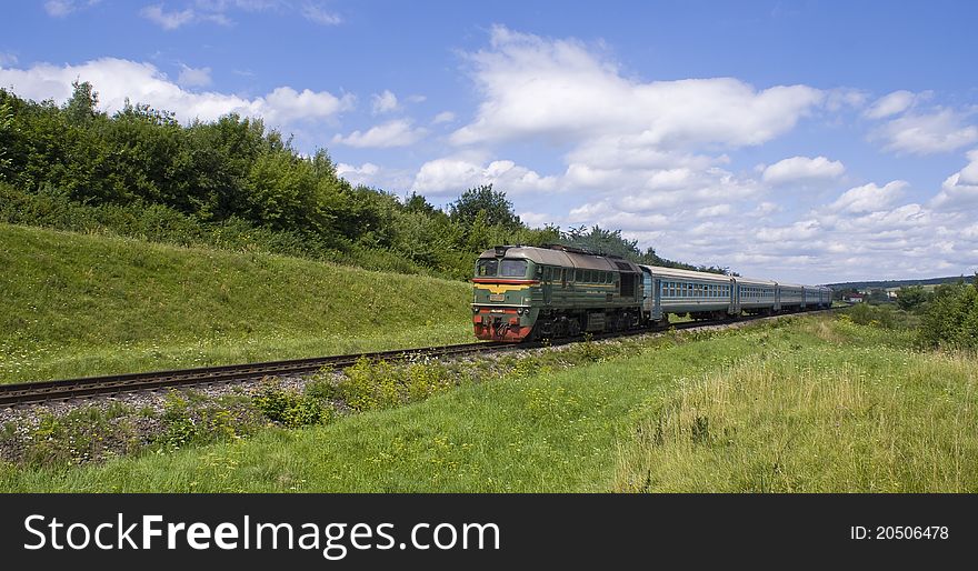 Diesel locomotive with passenger cars in prairie