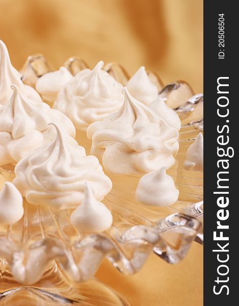 Meringues served over a glass cake stand. Selective focus, shallow DOF