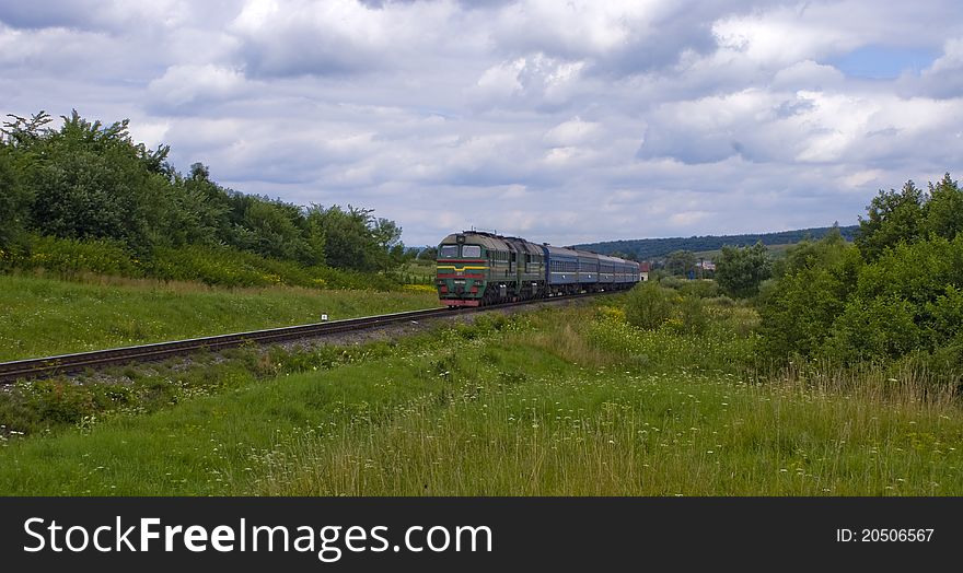 Diesel locomotive with passenger cars in prairie