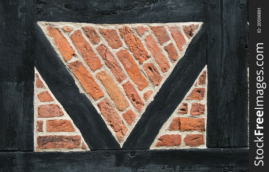 Panel in an old brick wall from 16th century. Illustrates old building principles and the strength of triangles but also suitable for a background.