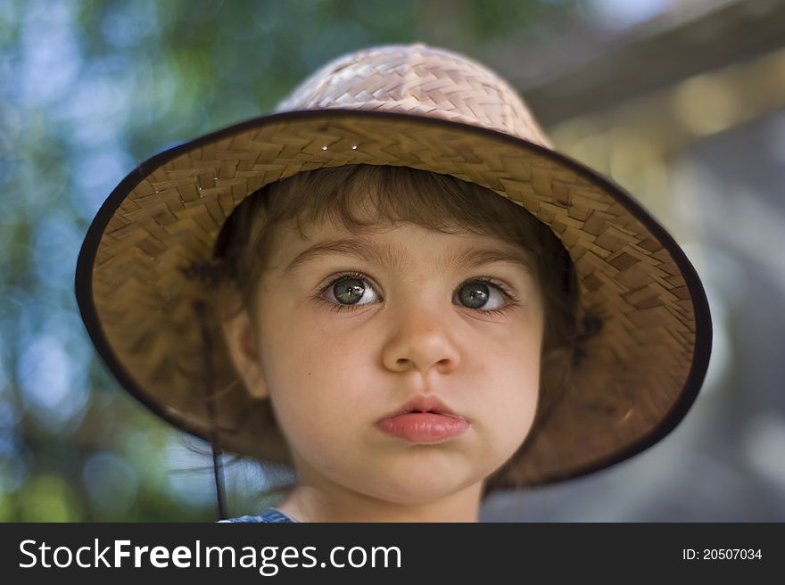 Portrait of the serious little girl with a hat, looking in a shot. Portrait of the serious little girl with a hat, looking in a shot