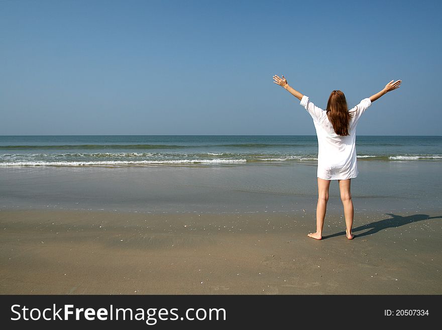 Woman on the beach near sea and blue sky