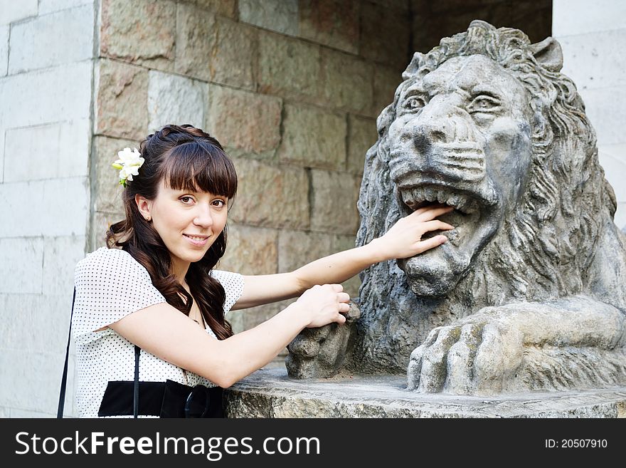 Young beautiful girl with lion statue