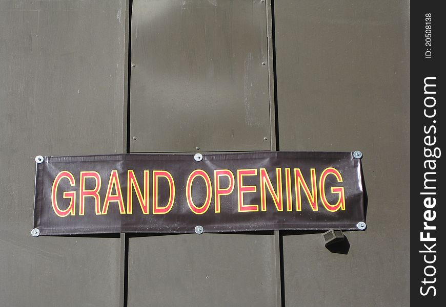 A sign stating a grand opening