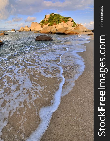 Rocky on sea beach coast and white foam under sunset warm lighting, shown as featured light, color and physiognomy. Rocky on sea beach coast and white foam under sunset warm lighting, shown as featured light, color and physiognomy.