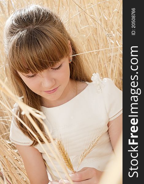 Girl wearing first communion dress in a field of grain. Girl wearing first communion dress in a field of grain