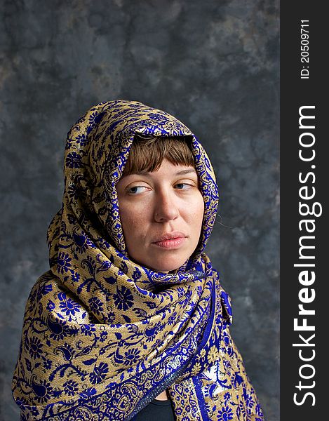 Portrait of a sad looking woman wrapped in a shawl and looking out the corner of her eyes. Portrait of a sad looking woman wrapped in a shawl and looking out the corner of her eyes.