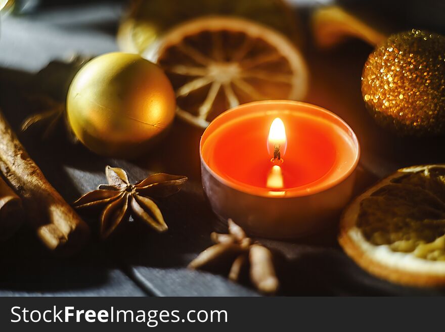 Close up view of burning candle, anise, cinnamon stick and dried orange. Close up view of burning candle, anise, cinnamon stick and dried orange