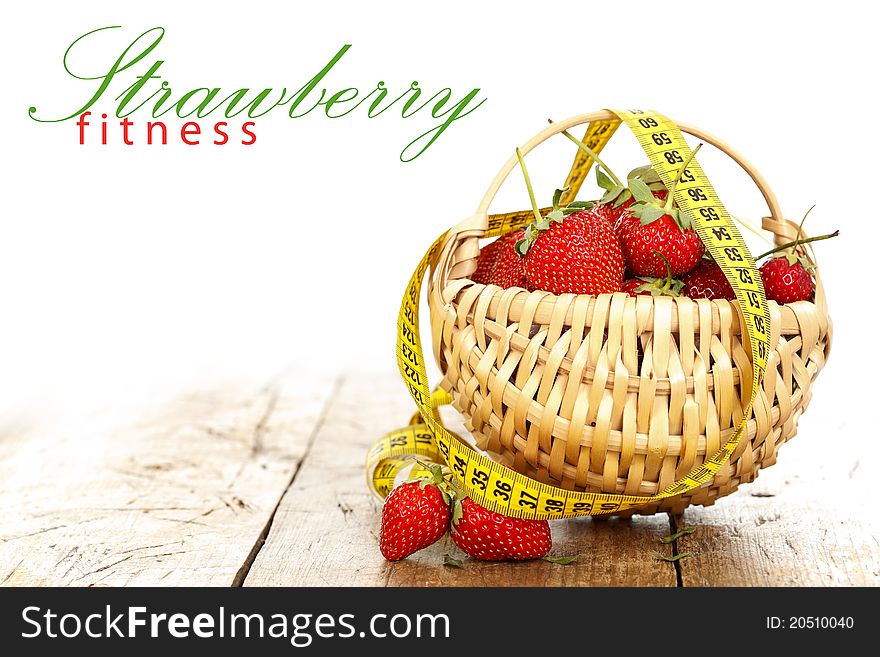 A basket full with strawberries and a measure tape around it, rustic style with place for your text. A basket full with strawberries and a measure tape around it, rustic style with place for your text