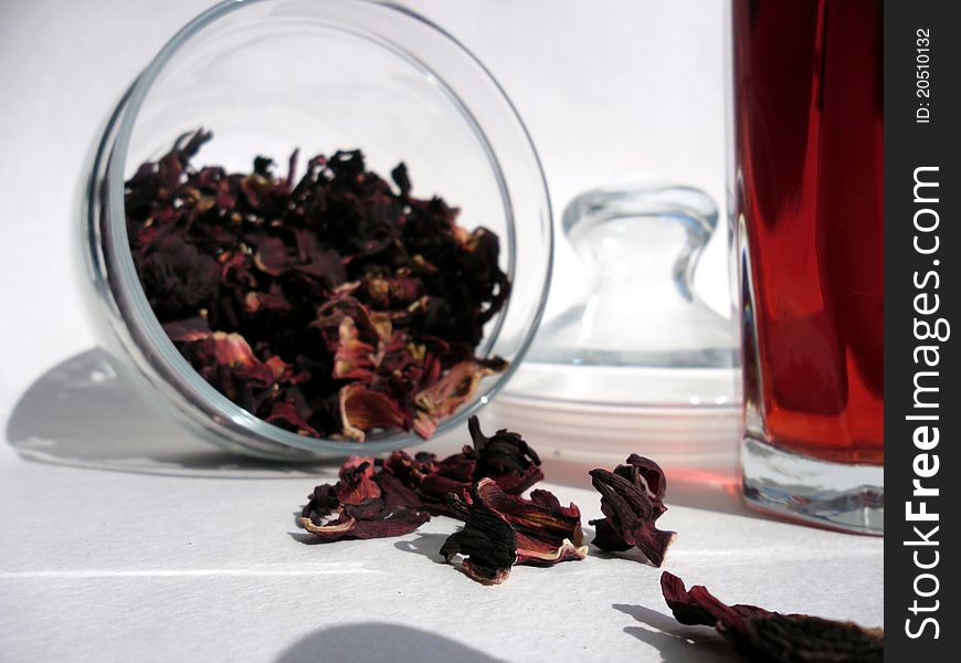 Red tea leaves in the opened jar and a glass of tea. Red tea leaves in the opened jar and a glass of tea.