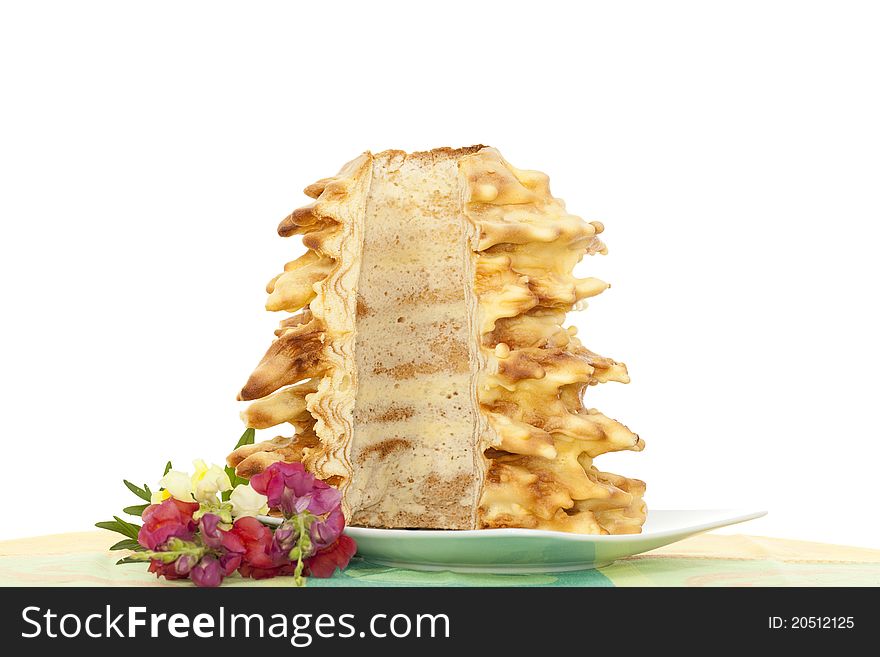 Cut sponge-cake on plate on white background