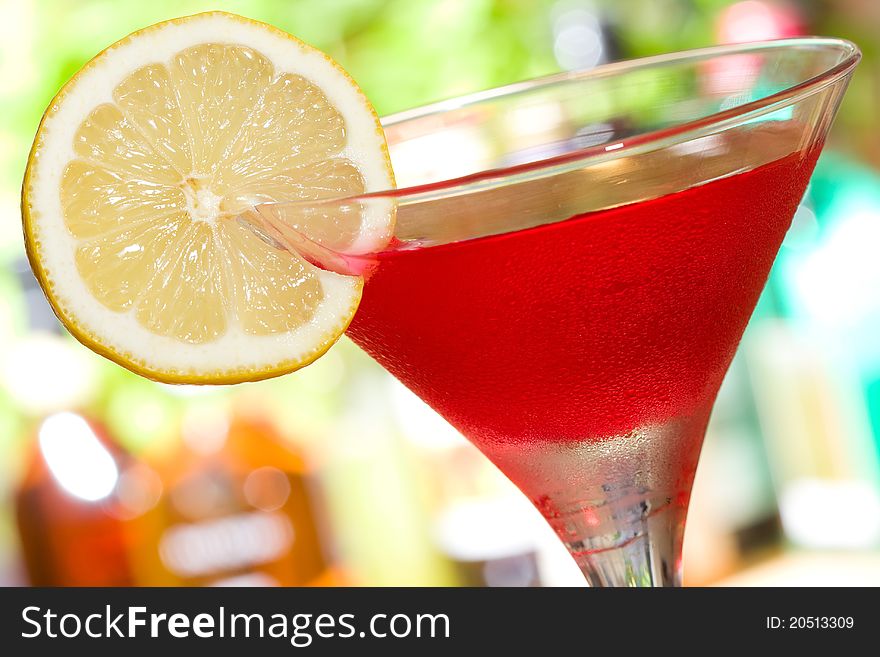 Red cocktail with slice of lemon