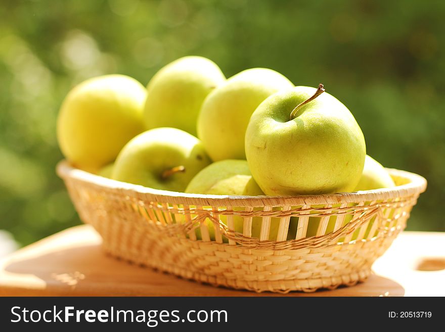 Green apples in a wicker plate