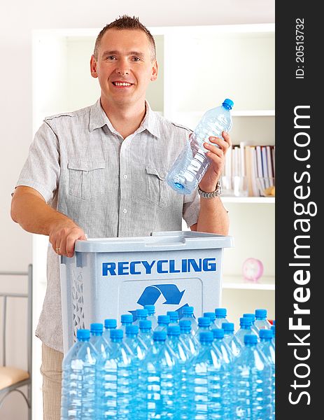 Happy man holding plastic bottle with recycling bin. Happy man holding plastic bottle with recycling bin