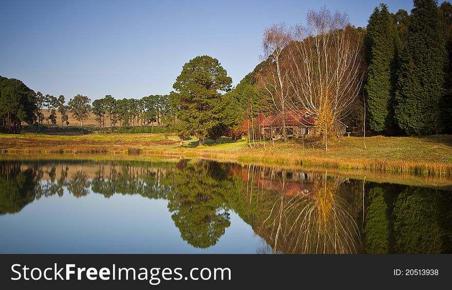 Long exposure image of a dam and autumn trees and small house