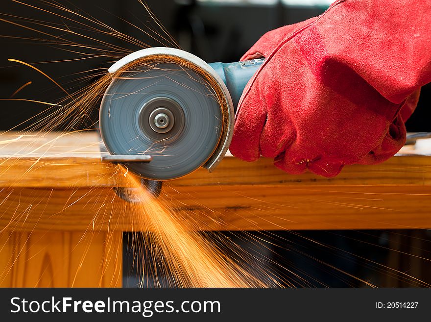 Cutting steel with a small grinder with sparks flying