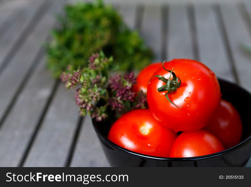 Tomatoes In Black Bowl With Herbs