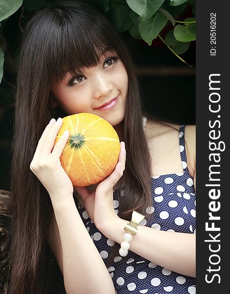 Young Chinese girl holding a melon outdoor portrait in summer. Young Chinese girl holding a melon outdoor portrait in summer.