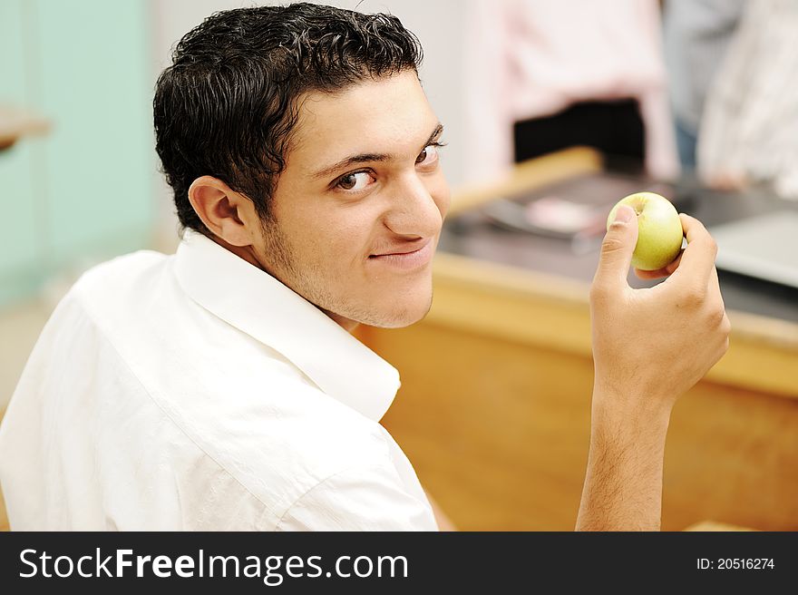 Student in collage with an apple in hand smiling