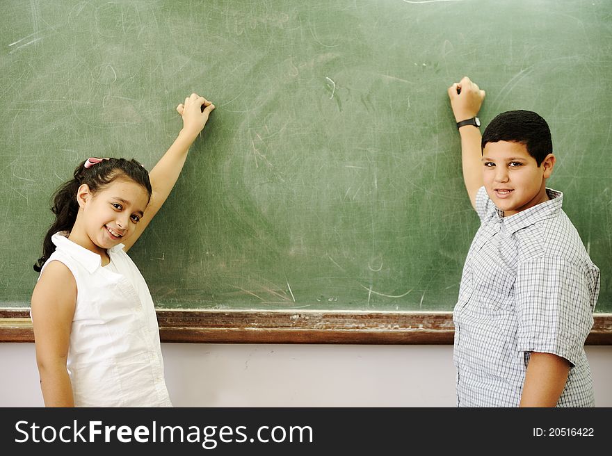 Boy and girl in front of school board. Boy and girl in front of school board