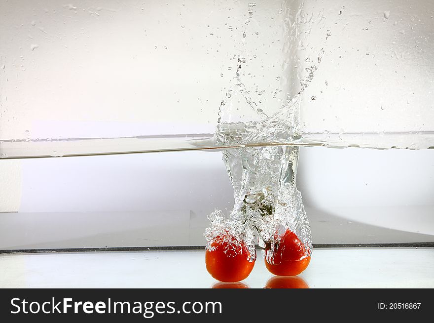 Bunch of tomatoes falling in water