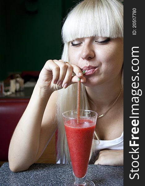 Young woman drinks cocktail