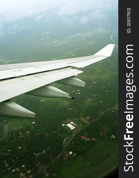 Aeroplane wings over green landscape