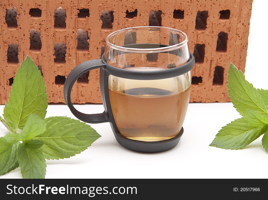 Peppermint tea with mint in front of brick