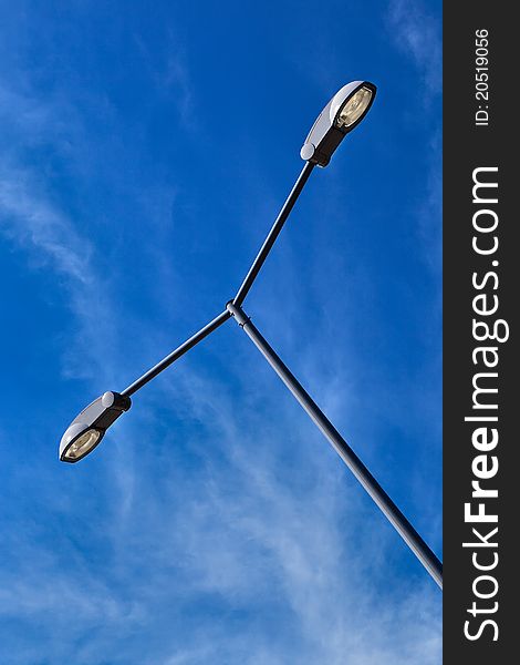 Modern electric street light pole over blue sky with clouds. Modern electric street light pole over blue sky with clouds.