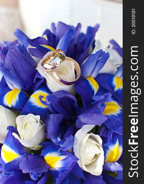 Wedding rings on wedding bouquet of irises