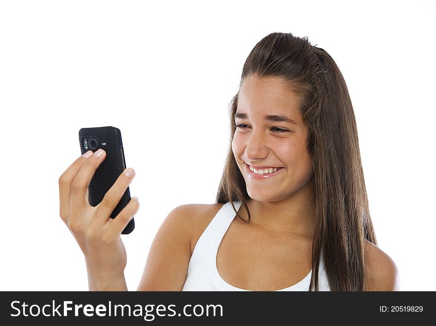 Cute teenager smiling with a mobile phone isolated on white