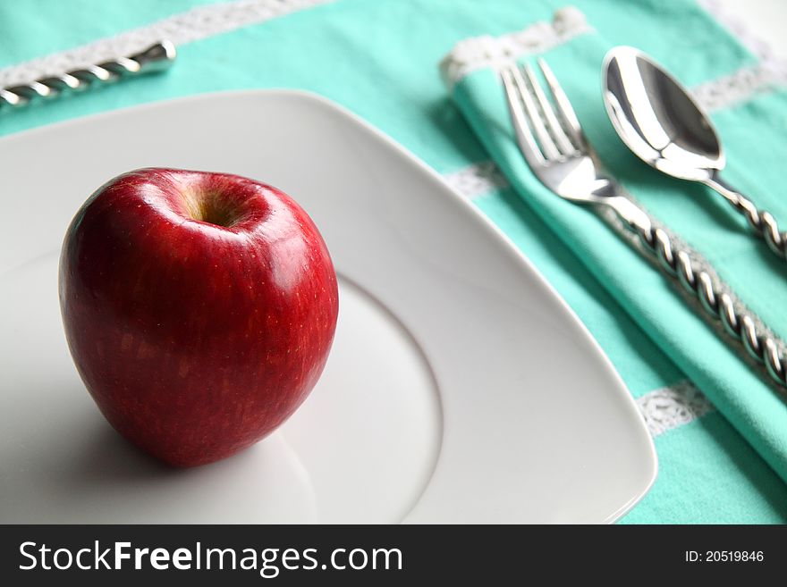 Still life of an apple on a white plate