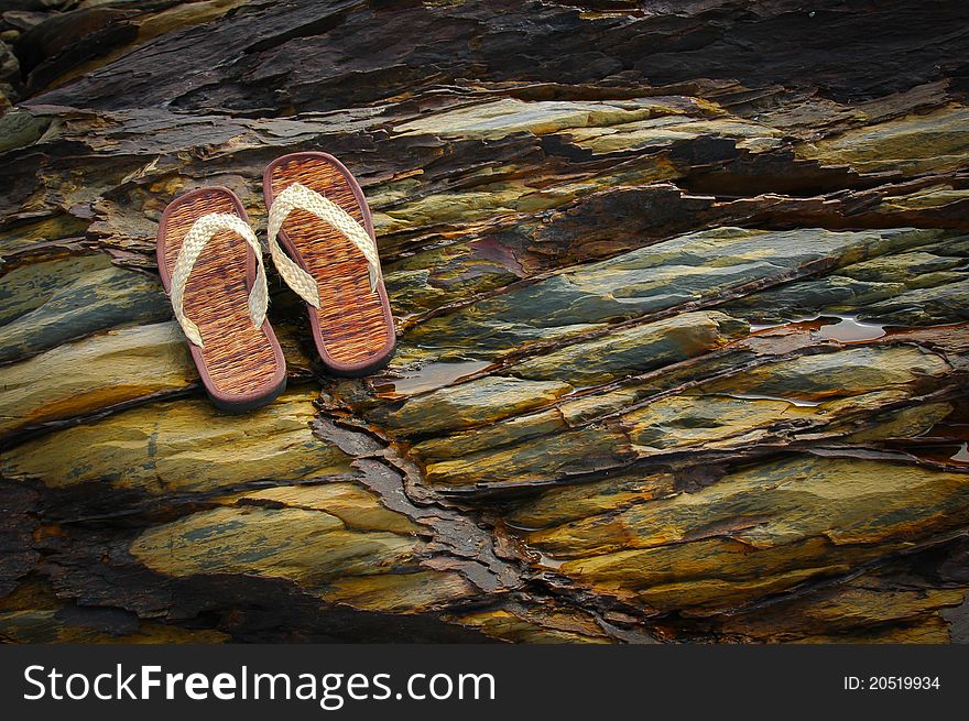 Flip flop on the rock of the beach