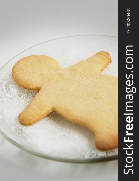 Christmas cookie shaped as gingerbread man on glass plate